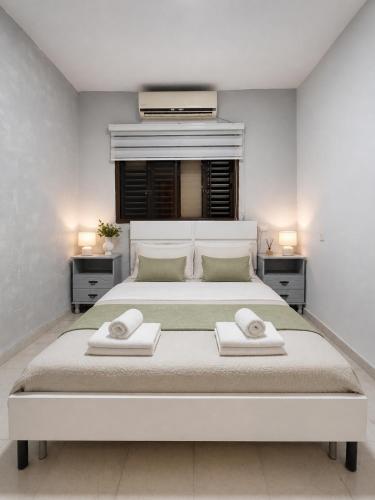 a bedroom with a large white bed with two towels on it at Sea view panorama 62 in Haifa