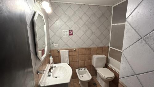 a small bathroom with a sink and a toilet at Hotel Atlántico Suites in Mar del Plata