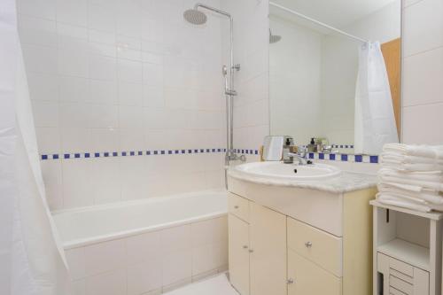 a white bathroom with a sink and a shower at Cantinho Lusitano in Portimão