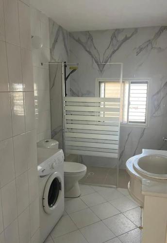 a bathroom with a toilet sink and a washing machine at Sea view panorama 62 in Haifa