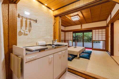 a kitchen with a sink and a living room at 民泊YADOOR East House & West House in Iga