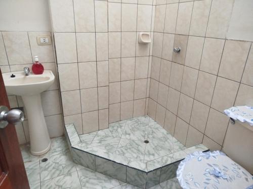 a bathroom with a sink and a shower with a glass floor at Casa independiente de 2 pisos con 03 cuartos in Morales