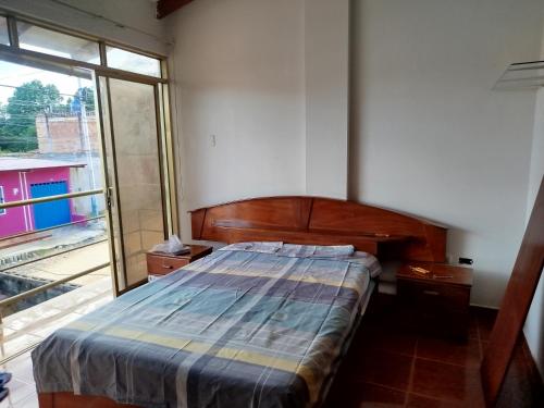 a bedroom with a bed and a large window at Casa independiente de 2 pisos con 03 cuartos in Morales