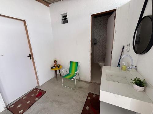 a bathroom with a sink and a chair in a room at Casa por temporada - Espaço Oxente - Lazer e eventos in Paulo Afonso