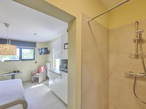 a bathroom with a shower and a bed in a room at Huus 16 in Zutendaal