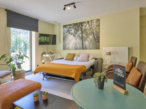 a bedroom with a bed and a living room at Huus 16 in Zutendaal