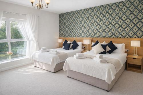 a bedroom with two beds and a window at The Dark Hedges Hotel in Stranocum