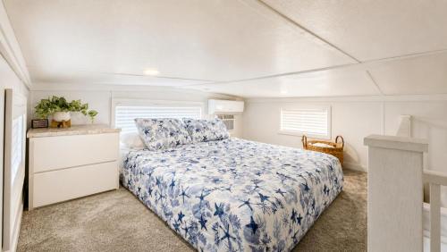 a bedroom with a bed with a blue floral bedspread at Happier in the Keys Waterfront Tiny Home in Key Largo