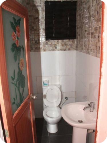a bathroom with a toilet and a sink at Kadosh Homes - 2Bed Apartment in Magboro