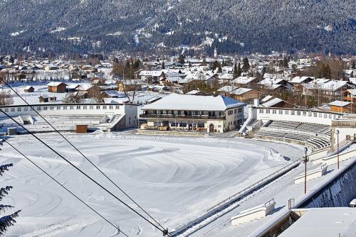 a snow covered city with a building and a mountain at Olympiahaus in Garmisch-Partenkirchen