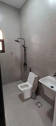 a bathroom with a toilet and a sink at رزات كاسا - للعائلات فقط in Gharnūt