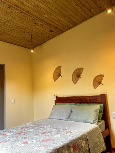 a bedroom with a bed with umbrellas on the wall at Casa verde in Fortim