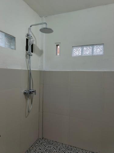 a shower stall in a bathroom with a window at Tetebatu Backpackers Base in Selong