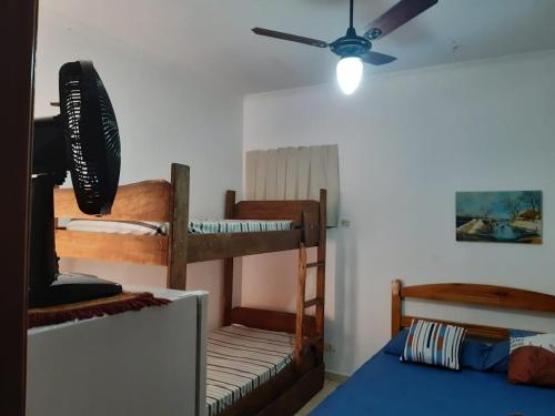 a bedroom with two bunk beds and a ceiling fan at Recanto Praia Peruibe in Peruíbe