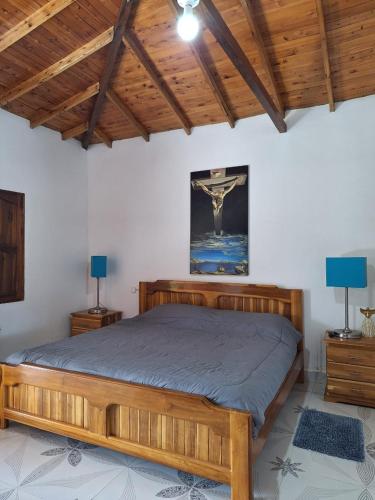 a wooden bed in a room with two lamps at finca nalu in Jardin