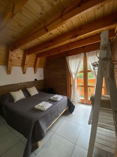 a bedroom with a bed in a wooden house at Cabañas Damel in Villa Giardino