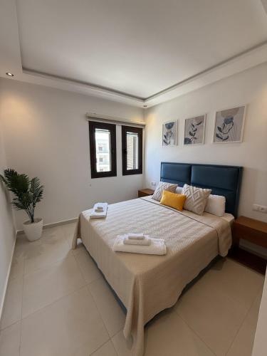 a bedroom with a large bed with two towels on it at Cozy Flat Sea & Hills View in Marina Smir