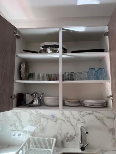 a kitchen with a sink and a counter with plates at Cozy Flat Sea & Hills View in Marina Smir