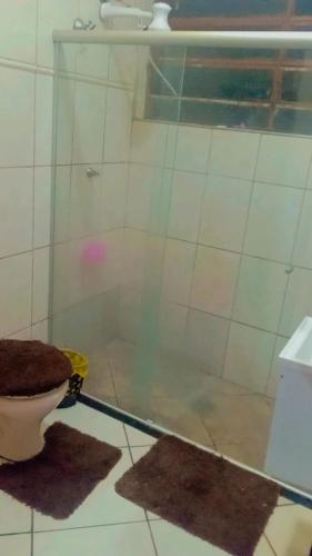 a bathroom with a glass shower with a toilet at Pousada May in Ribeirão Preto