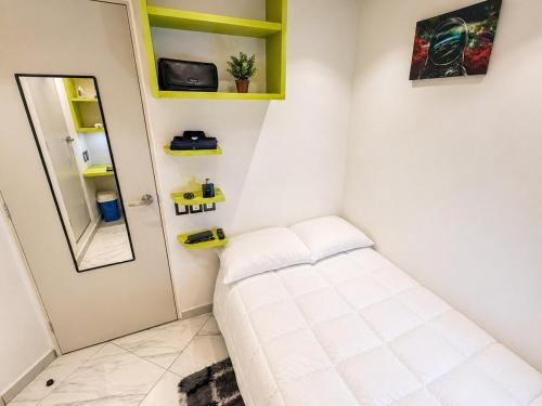 a small room with a bed and a mirror at Habitación individual con baño privado a 2 min de Ciudad Universitaria - UNAM - Institutos de Investigación in Mexico City