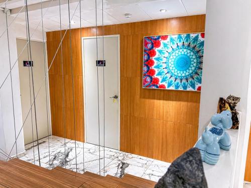 a bathroom with a mirror and a painting on the wall at Habitación individual con baño privado a 2 min de Ciudad Universitaria - UNAM - Institutos de Investigación in Mexico City