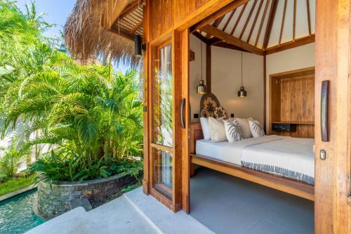 a bedroom in a villa with a bed at MELO Gili Air in Gili Islands