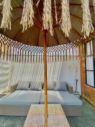 a tent with two beds and an umbrella at Baliris Home Boutique Legian in Seminyak