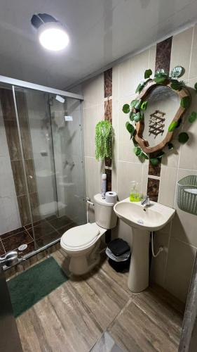 a bathroom with a toilet and a sink and a shower at Hospedaje Salento in Salento