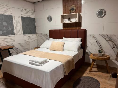 a bedroom with a large bed with white sheets at Hospedaje Salento in Salento