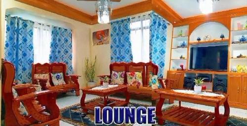a living room with red chairs and a television at 3 J'S Homestay in Carles