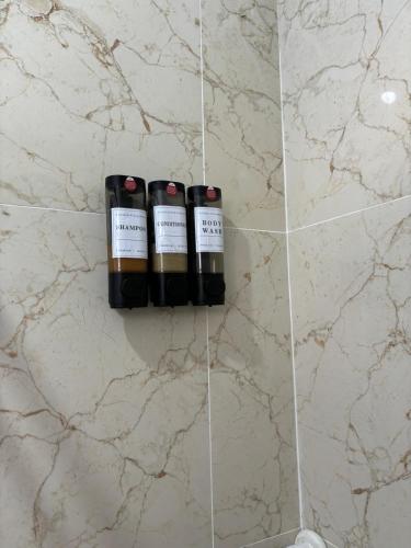 three bottles of wine on a wall in a bathroom at Casa Cielo y Noche in Ahuachapán
