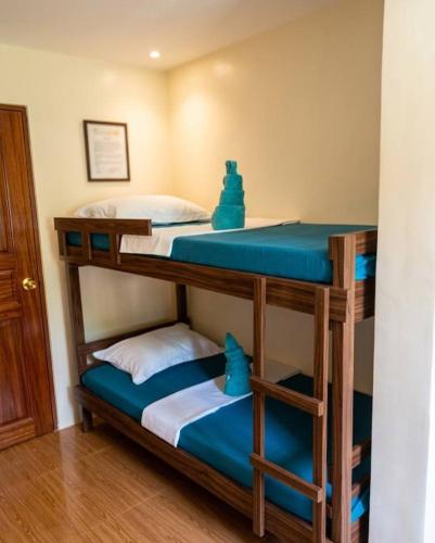 two bunk beds in a room with blue sheets at 3 J'S Homestay in Carles