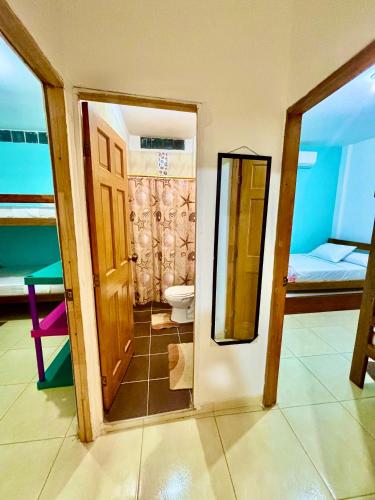 a bathroom with a toilet and a door to a room at Cabañas Turísticas Castrolandia in San Antero