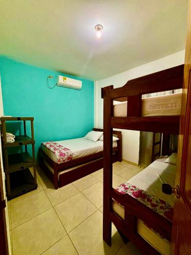 a bedroom with two bunk beds and a blue wall at Cabañas Turísticas Castrolandia in San Antero