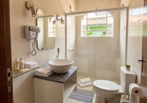 a bathroom with a sink and a toilet and a shower at Cantinho no litoral a 100mts da praia in São Sebastião