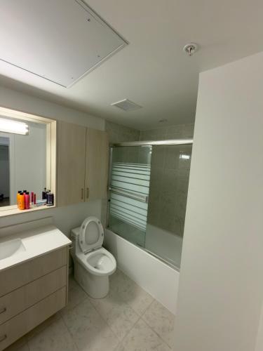 a bathroom with a toilet and a glass shower at Downtown Escape in Surrey