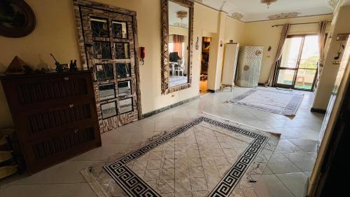 a living room with a tile floor and a mirror at Temple host in Cairo