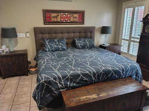 a bedroom with a bed with a black comforter and pillows at 1 bed room dog friendly accommodation in Tarneit