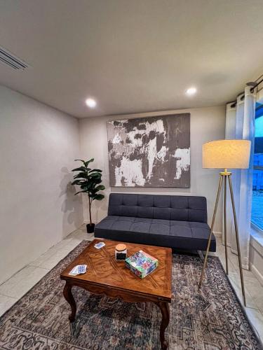 a living room with a blue couch and a table at The Oasis - 2 Private Homes, Pool, and BBQ in New Port Richey