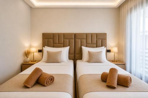 two beds in a hotel room with towels on them at Madani Palazza Appart & Duplex in Marrakesh
