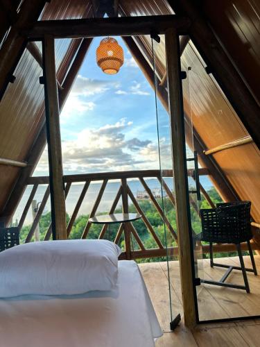 a bed in a room with a view at Chalé Pontal da Juacema in Ilha Cachoeira