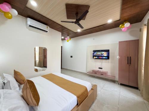 a bedroom with a bed and a flat screen tv at Hotel Staywell in Karnal