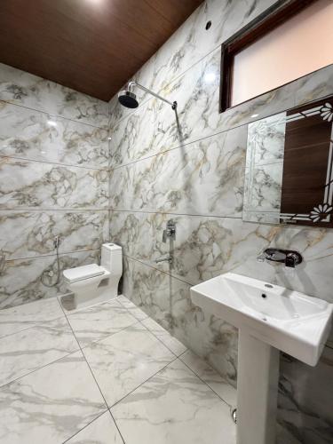 a white bathroom with a sink and a mirror at Hotel Staywell in Karnal