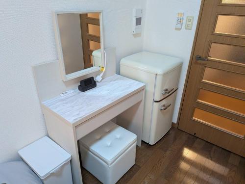 a bathroom with a sink and a mirror and a refrigerator at 大濠ウエストヴィレッジ409 in Fukuoka