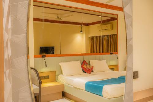 a small bedroom with a bed and a mirror at Hotel Prince Residency, Bhuj in Bhuj