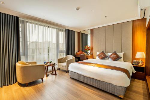 a hotel room with a large bed and a desk at Aroma Hotel An Khánh in Vân Lũng