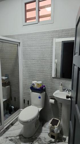 a bathroom with a toilet and a sink at Casa Lujosa in Choluteca