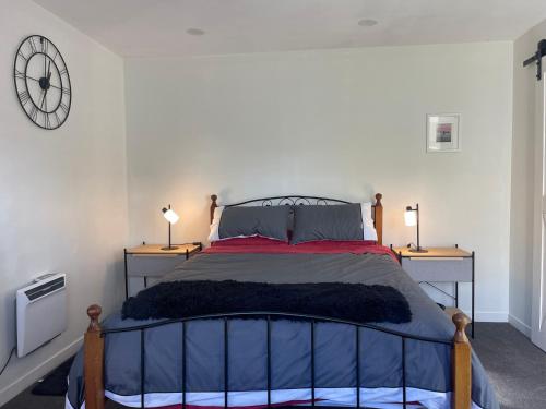 a bedroom with a large bed with two night stands at Kaiapoi Village Le Shack in Kaiapoi