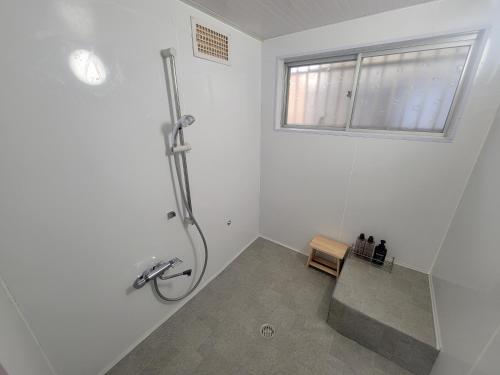 a white bathroom with a shower and a sink at Rinku Base Ichi in Tajiri