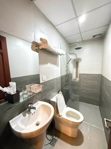 a bathroom with a toilet and a sink at Salux Hotel in Danang